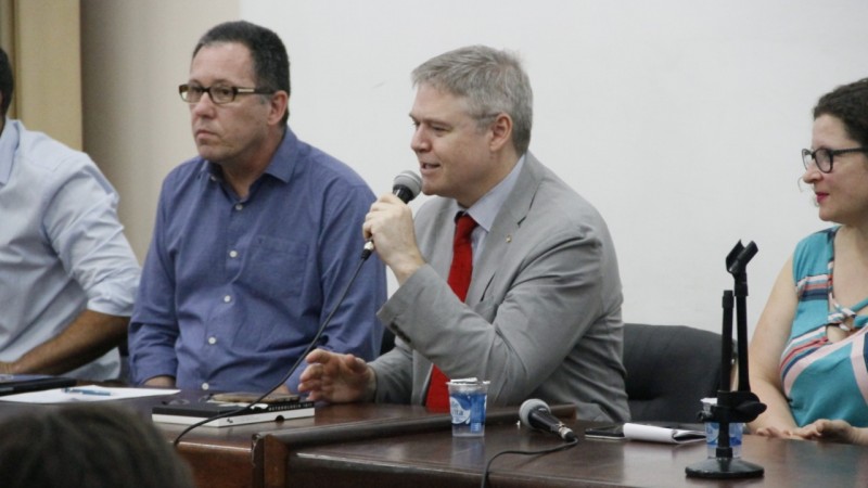 A foto mostra o secretário Luís Lamb falando com um microfone na mão.