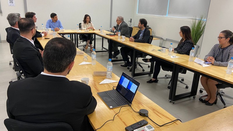 Pessoas sentadas em volta de uma mesa de reunião
