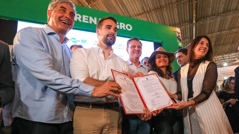 Foto com pessoas segurando o protocolo assinado