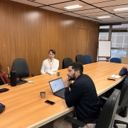 Quatro pessoas sentadas em volta da mesa, em reunião. 