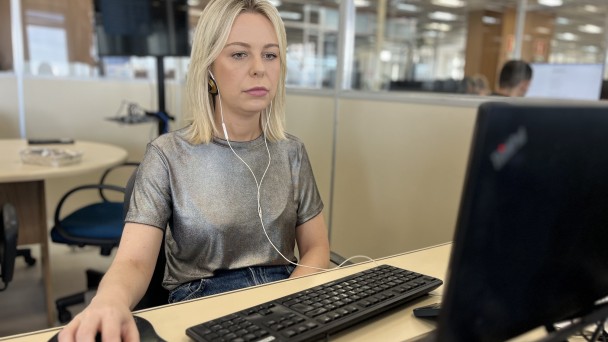 Foto da diretora Paola em frente ao notebook durante a live 