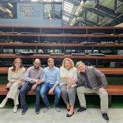 cinco pessoas sentadas em uma arquibancada.