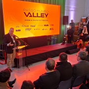 Palestrante fala em um palco diante de plateia, com tel&atilde;o laranja ao fundo exibindo &ldquo;Passo Fundo Valley &ndash; onde o futuro nasce&rdquo; e logos de apoiadores.
Audit&oacute;rio moderno com p&uacute;blico sentado em cadeiras e arquibancada, ilumina&ccedil;&atilde;o quente e foco no evento de inova&ccedil;&atilde;o.